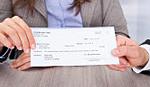 Two hands holding a check
