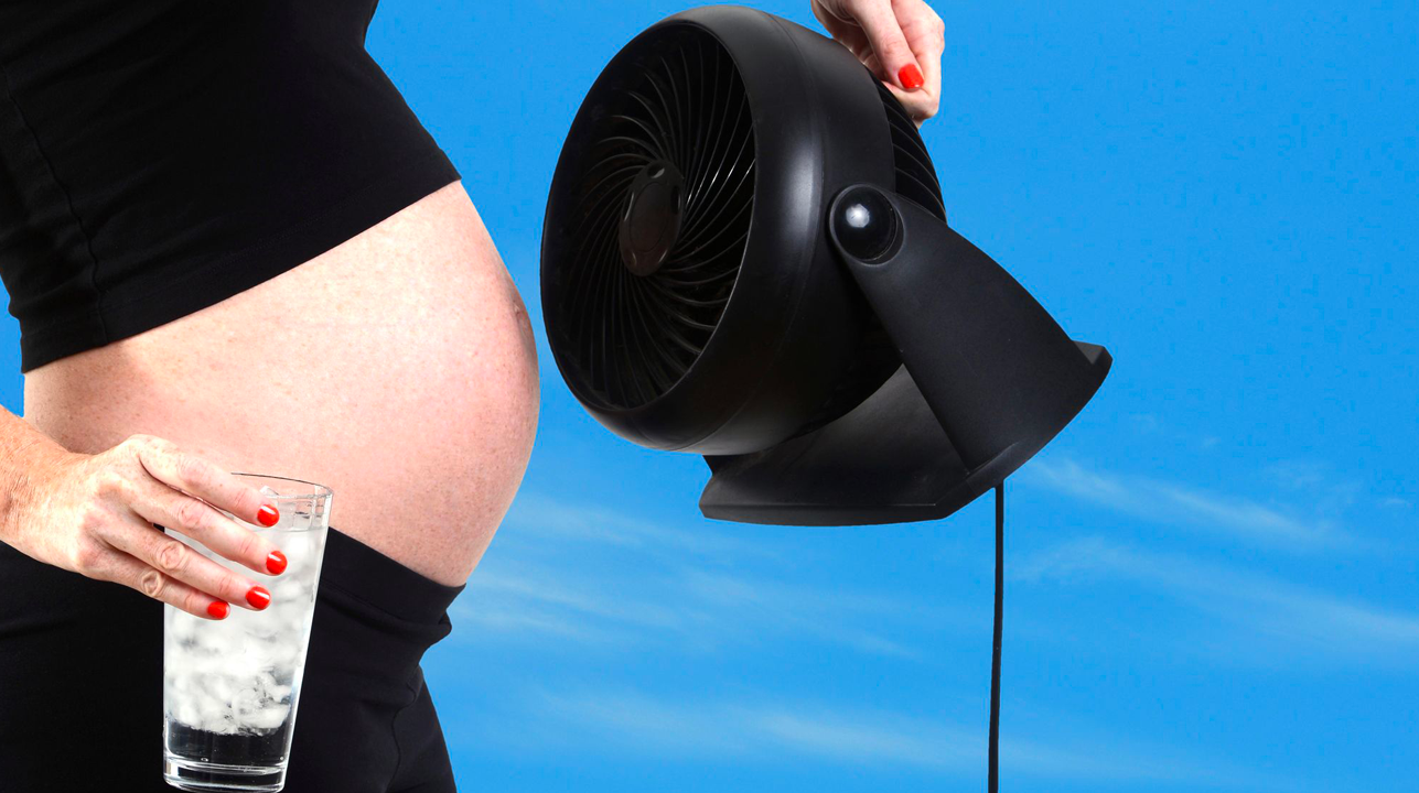 pregnant woman holding iced water and fan