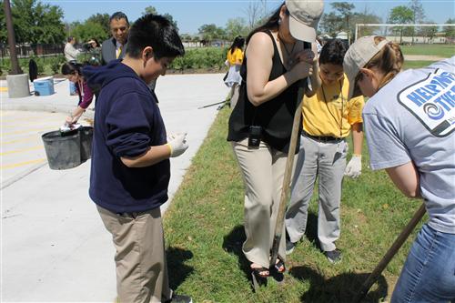 Mrs. Hernandez planting a tree.