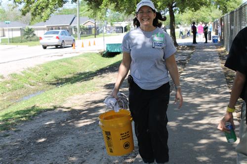Ms. Jamie Vazquez, President of W&T Offshore, Inc. carries a pail of water to her recently planted tree.